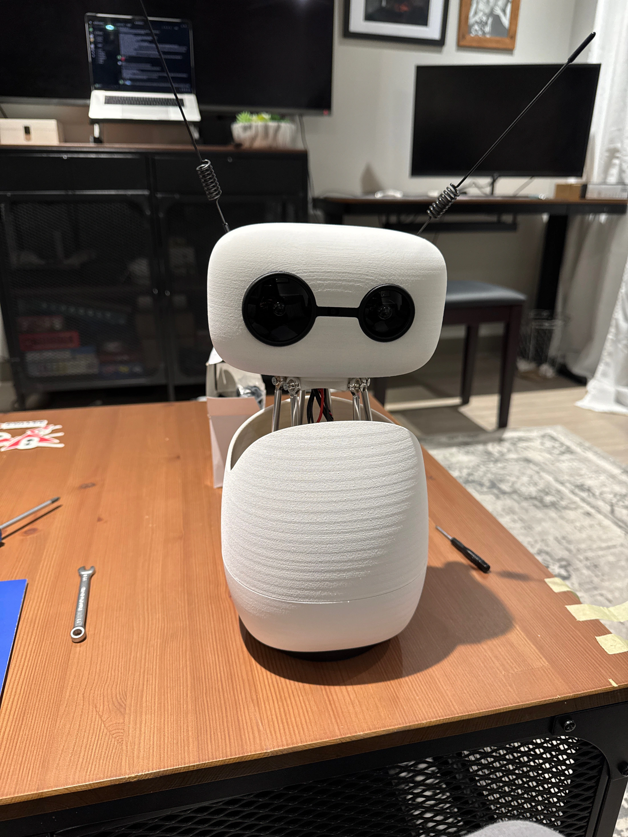 Assembled Reachy Mini robot standing on a table with tools nearby