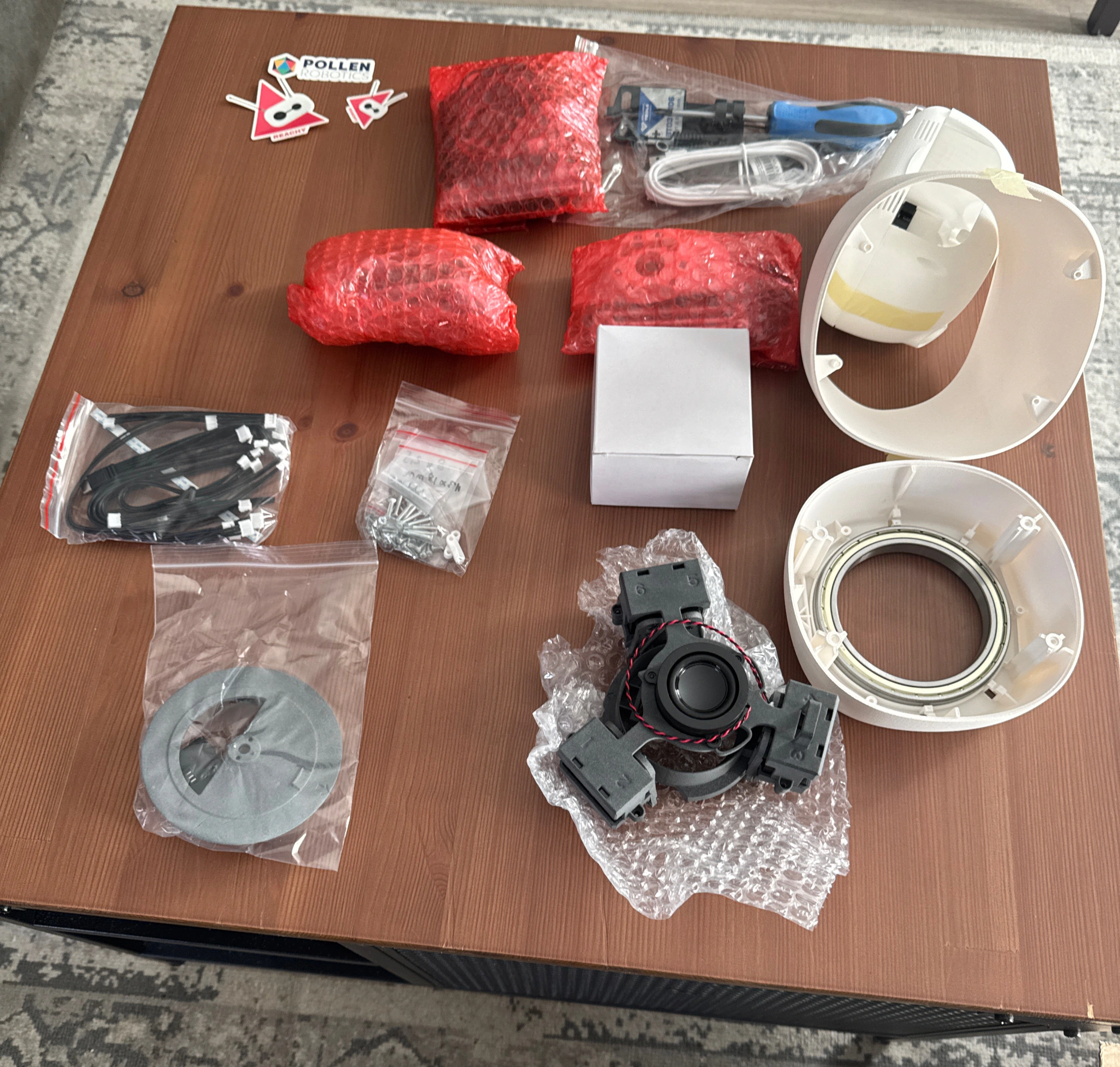 Reachy Mini kit parts laid out on a table before assembly
